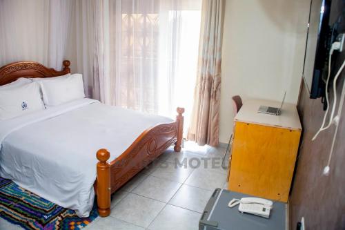 a bedroom with a bed and a television in a room at Harts Motel in Kampala