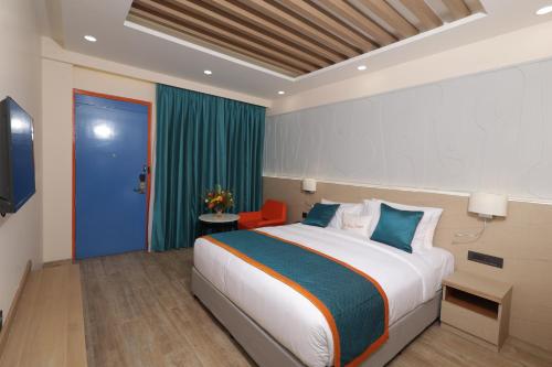 a bedroom with a large bed and a blue door at Zone Connect by The Park Patna 