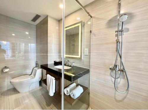 a bathroom with a shower and a toilet and a sink at Panorama Nha Trang Sunlight Apartment in Nha Trang