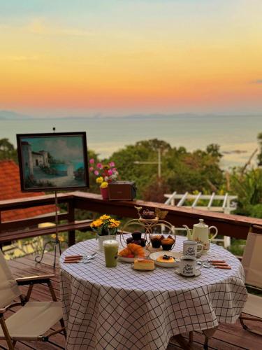 a table with food and a television on a balcony at VELAMUNDi INN Batu Ferringhi in Batu Ferringhi