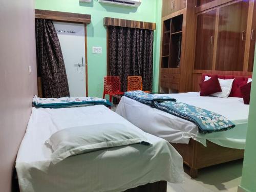 a bedroom with two beds and chairs in it at Shri Shiva Homestay by VM Stays in Varanasi