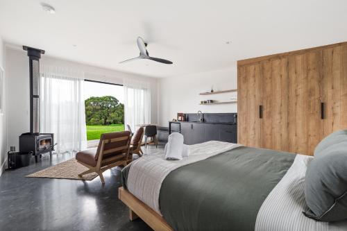 MetricupにあるChalet Grove, Walburra Brookの大きなベッドと暖炉のある寝室