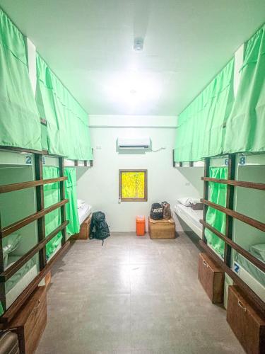 ein Zimmer mit zwei Etagenbetten und einem Fenster in der Unterkunft Sunset Surf Hostel Siargao in General Luna