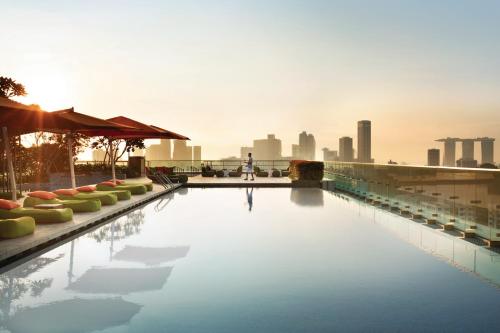 a swimming pool with a city skyline in the background at JEN Singapore Orchardgateway by Shangri-La in Singapore