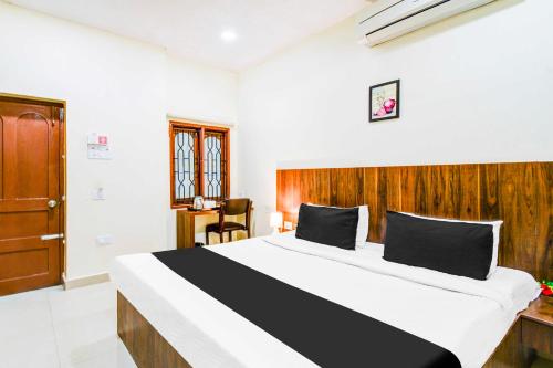 a bedroom with a large bed with a wooden headboard at Townhouse Oak Begumpet Railway Station in Hyderabad