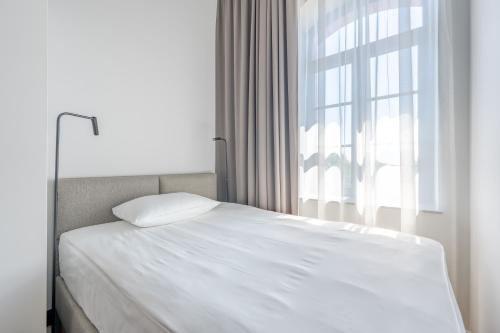 a white bed in a room with a window at Noli Gdansk Old Town in Gdańsk