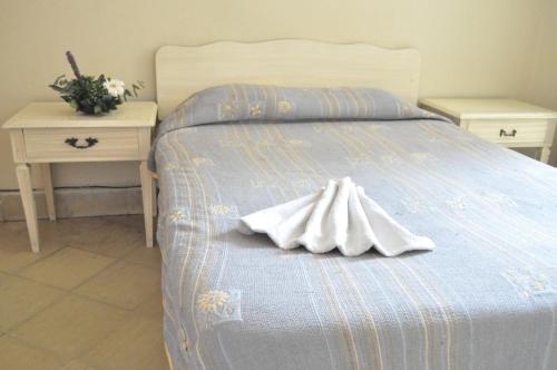 Una cama con toallas blancas y dos mesas. en Hotel Metropolitan I, en Irapuato