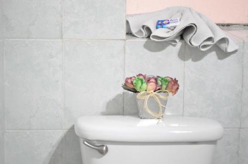 a vase of flowers sitting on top of a toilet at Hotel Metropolitan I in Irapuato