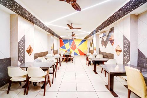 a restaurant with tables and chairs and colorful walls at Hotel O Civil Lines Rudrapur in Rudrapur