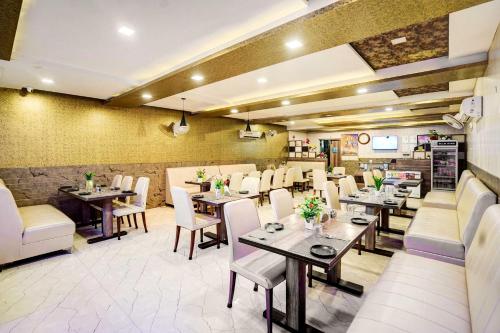 a dining room with tables and white chairs at Hotel O Civil Lines Rudrapur in Rudrapur