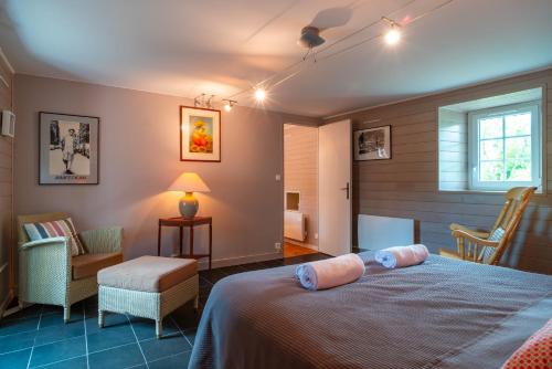 une chambre avec un lit, une chaise et une fenêtre dans l'établissement Ker West, à Carnac