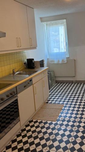 a kitchen with a black and white checkered floor at Boho Bliss Apartments in Delémont
