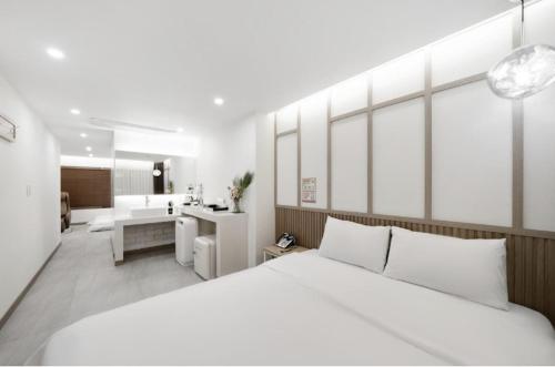 a bedroom with a large white bed and a bathroom at Hotel Yaja Gwangju Mudeungsan branch in Gwangju