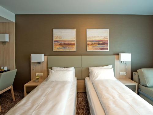 a hotel room with two beds and two lamps at Hotel Molo Resort in Osiek