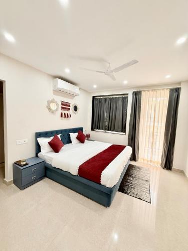 Un dormitorio con una cama grande con almohadas rojas. en Nivasa, en Dehradun