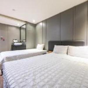 two beds in a room with two beds sidx sidx sidx at Geoje MVG Motel in Geoje 