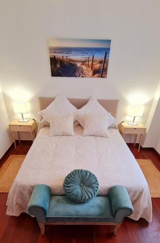 a bedroom with a large bed with a blue couch at Bajo con jardin Costa Quebrada in Liencres