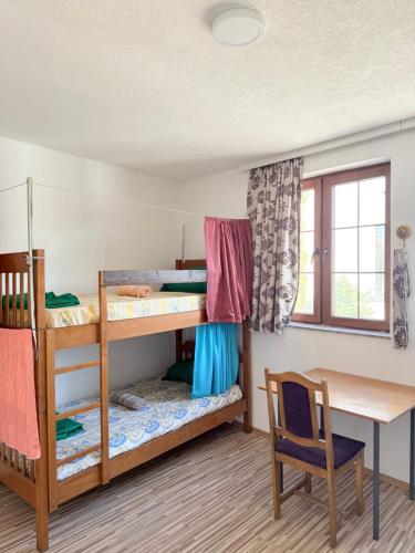 a room with two bunk beds and a desk at Hattuşa Hostel in Prizren