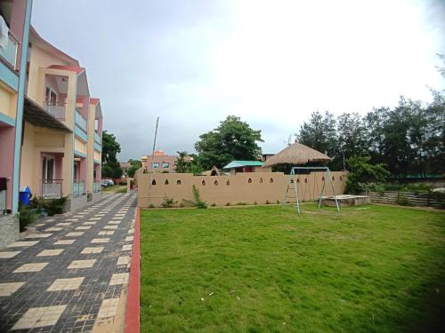 a wall with a grass yard next to a building at The Sea Horse in Mandarmoni