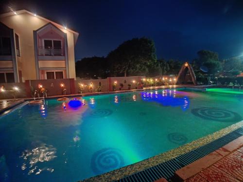 a swimming pool at night with lights on it at The Sea Horse in Mandarmoni