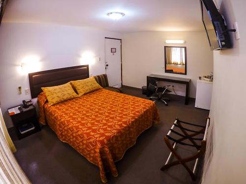 a bedroom with a bed and a desk in it at Intiotel Chiclayo in Chiclayo