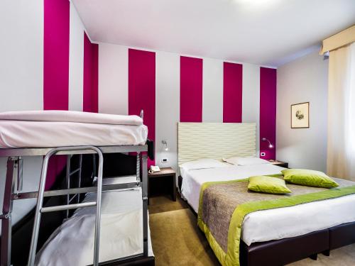 a bedroom with two bunk beds and purple and white stripes at Cristallo Wellness Hotel in Aprica