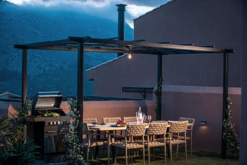a patio with a table and chairs and a grill at Arcasa Villas Collection by Omilos Hotels in Archanes