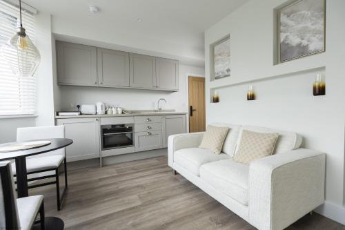 a white living room with a couch and a table at Bell House Oxford - The Dove in Oxford