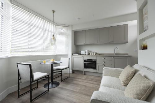 a kitchen and living room with a table and a couch at Bell House Oxford - The Dove in Oxford