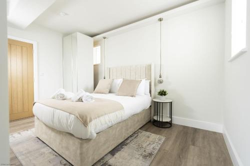 a white bedroom with a large bed with white walls at Bell House Oxford - The Dove in Oxford