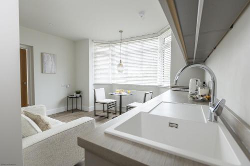 a kitchen and living room with a couch and a table at Bell House Oxford - The Dove in Oxford