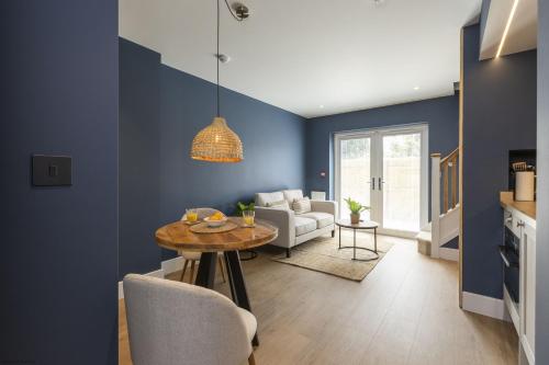 a living room with blue walls and a table at Bell House Oxford - The Chalet in Oxford
