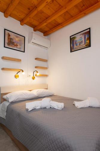 a bedroom with two beds and two lights on the wall at Green Bay Studio 1 in Sifnos