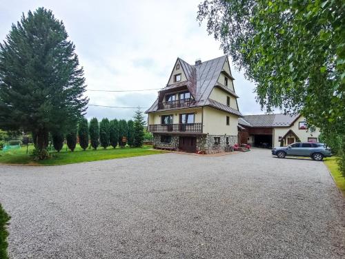 ein großes Haus mit einem Auto in der Einfahrt in der Unterkunft Pokoje pod Brzozami - zniżki na Termy i Rowery ! in Czarna Góra