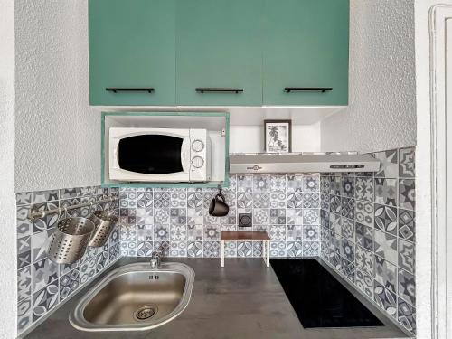 una cocina con fregadero y microondas en Studio cosy 4 pers à 150m de la plage !, en Le Barcarès