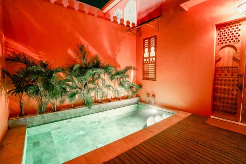 a swimming pool in a room with an orange wall at La Marrocco Villas in Nusa Penida