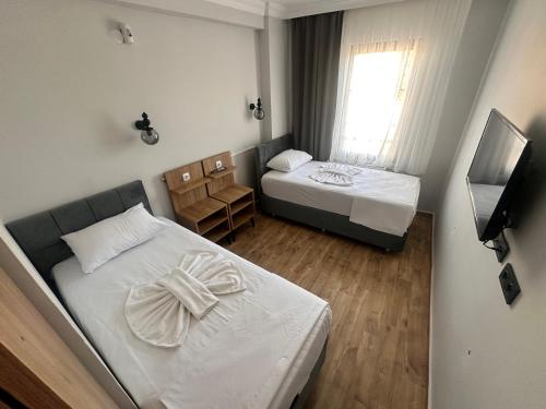 a small room with two beds and a television at Avka Palace in Edirne