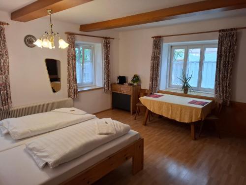 a bedroom with two beds and a table and windows at Gingin- rooms in Hallstatt