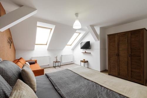 a living room with a couch and some windows at Vila Anna - Apartmány in Česká Lípa