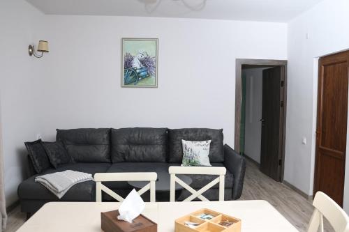 a living room with a black couch and a table at Tesaran Stepanavan Guest House, Apart Hotel in Stepʼanavan