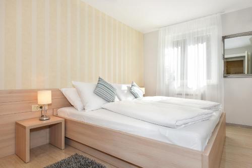 ein Schlafzimmer mit einem Bett mit weißer Bettwäsche und einem Fenster in der Unterkunft Villa Slavica 1 in Vodice