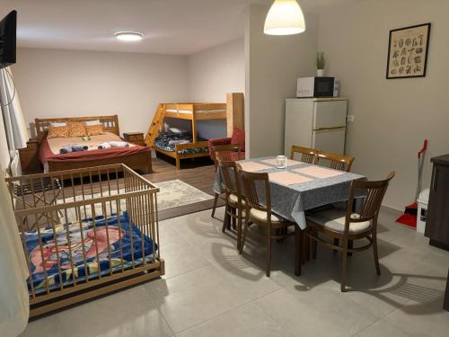 a living room with a table and chairs and a bedroom at Tündérrózsa Vendégház Pásztó in Pásztó