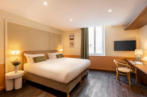 a hotel room with a large bed and a desk at Grand Hotel d'Orange, BW Signature Collection in Orange