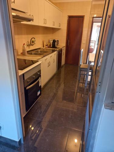 a small kitchen with a sink and a stove at Casa da Zendinha in Coimbra