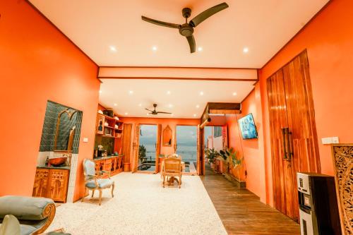 a living room with orange walls and a ceiling at La Marrocco Villas in Nusa Penida