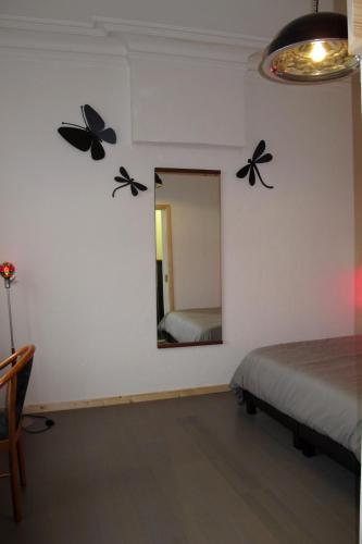 a bedroom with butterflies on the wall and a mirror at Stone Station in Esneux