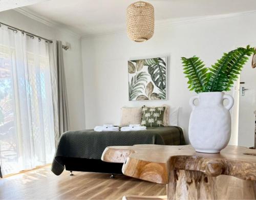 a bedroom with a bed and a vase with a plant at Barossa Palms Motel in Nuriootpa