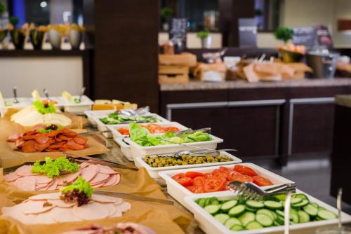 a buffet with several trays of food on a table at Park Inn by Radisson Sarvar Resort & Spa - All Inclusive in Sárvár