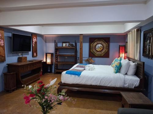 a bedroom with a bed and a television in it at On The Mekong Resort in Luang Prabang