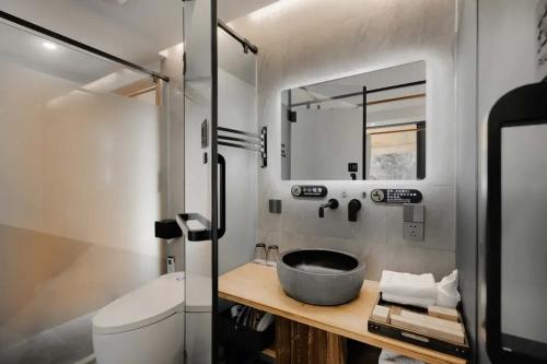 a bathroom with a sink and a toilet at Tengchong Nan Su Gu Li Hot Spring EnjoyLife Family Resort (Tengyue Culture Plaza Branch) in Tengchong
